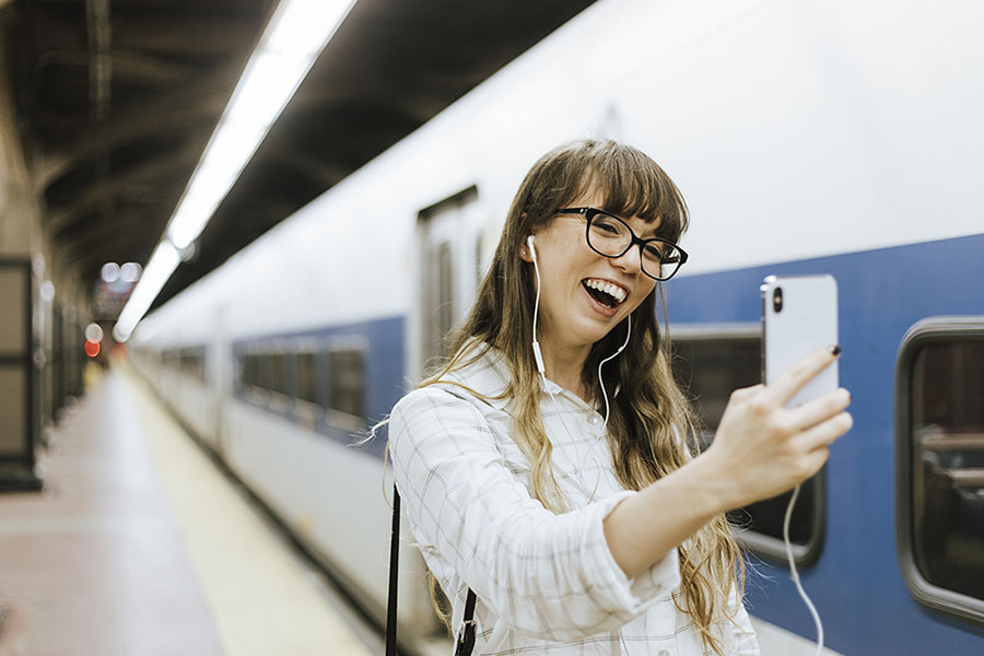 Cheerful woman having a video call at a subway platform